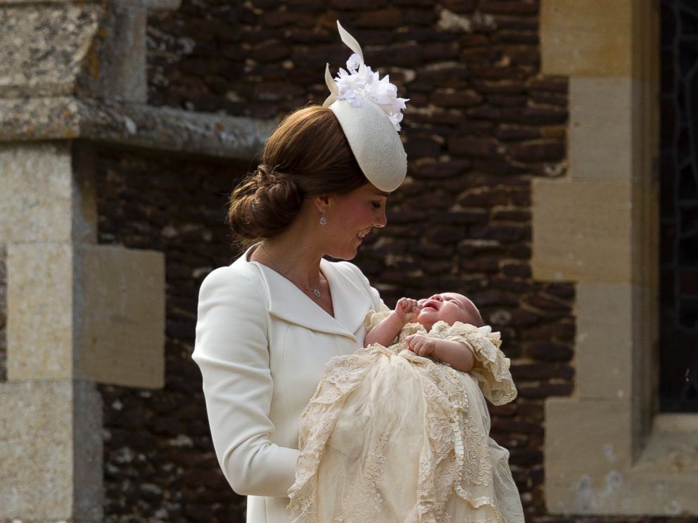 PHOTO: Britains Kate the Duchess of Cambridge carries Princess Charlotte after taking her out of a pram as they arrive for Charlottes Christening at St. Mary Magdalene Church in Sandringham, England, July 5, 2015. 