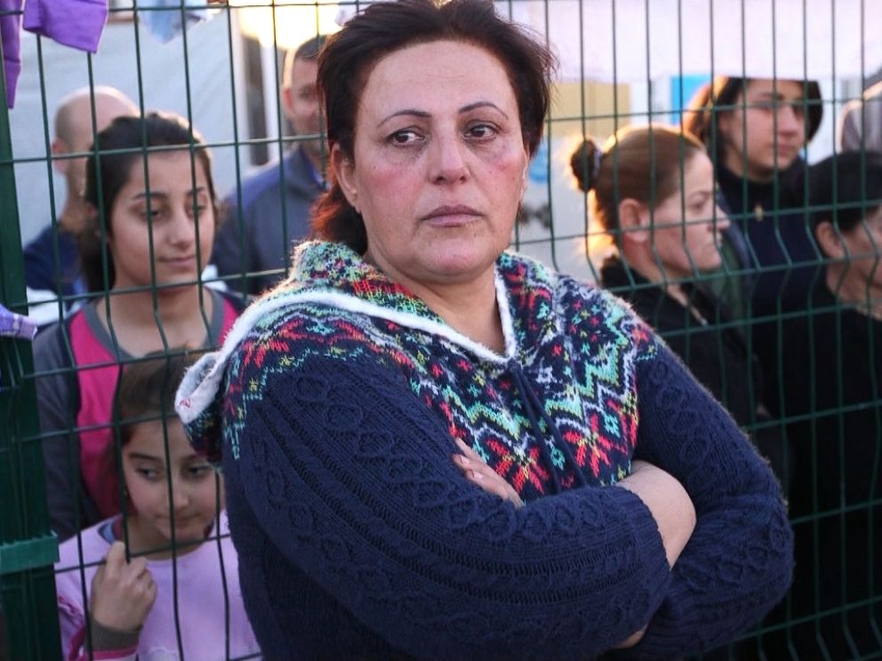 Majida Habeeb Gorgees, the cook for the refugee center in Erbil, Iraq, stands by a fence.