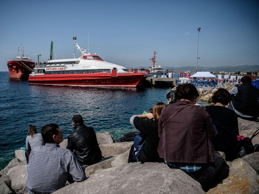 PHOTO: People gather on the beach as migrants deported from Greece arrive aboard a small Turkish ferry in the port of Dikili district in Izmir, Turkey, on April 4, 2016. 